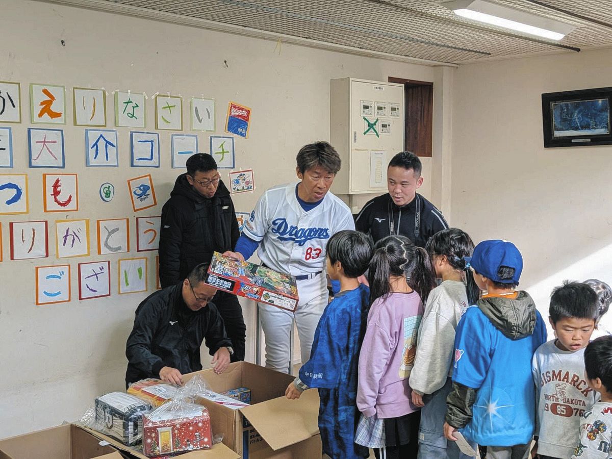 児童養護施設「旭が丘学園」を訪れ、園児たちにプレゼントを渡す中日・山井コーチ（左から３人目）