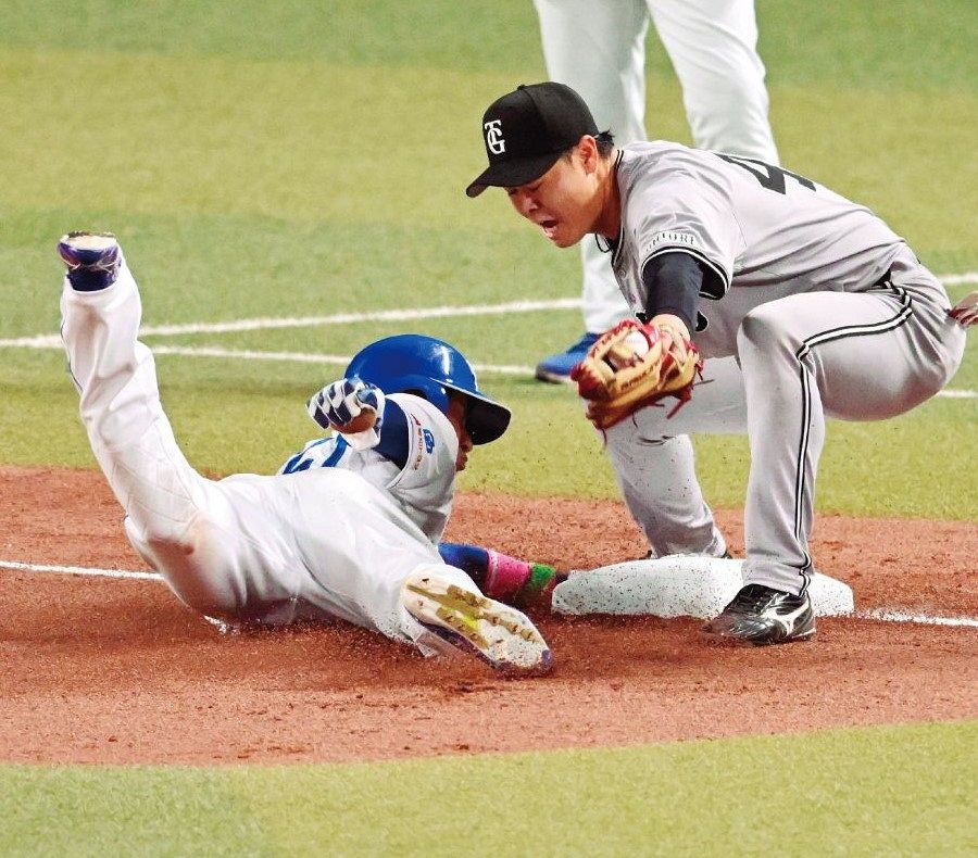 中日─巨人 7回裏無死二塁、村松の送りバントで三塁にヘッドスライディングする代走上林。三塁手・中山、三塁塁審・水口=2025年4月1日、バンテリンドームナゴヤで