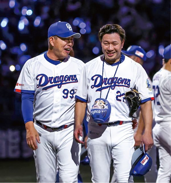 青いだるまを首から下げた大野と言葉を交わす井上監督＝４月２日、バンテリンドームナゴヤで