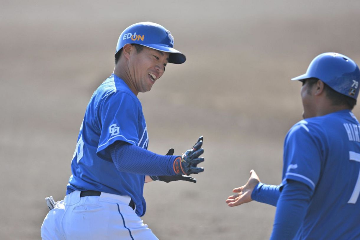 2回表、先制ソロを放ち平田コーチとタッチを交わす鵜飼=安芸市営球場で