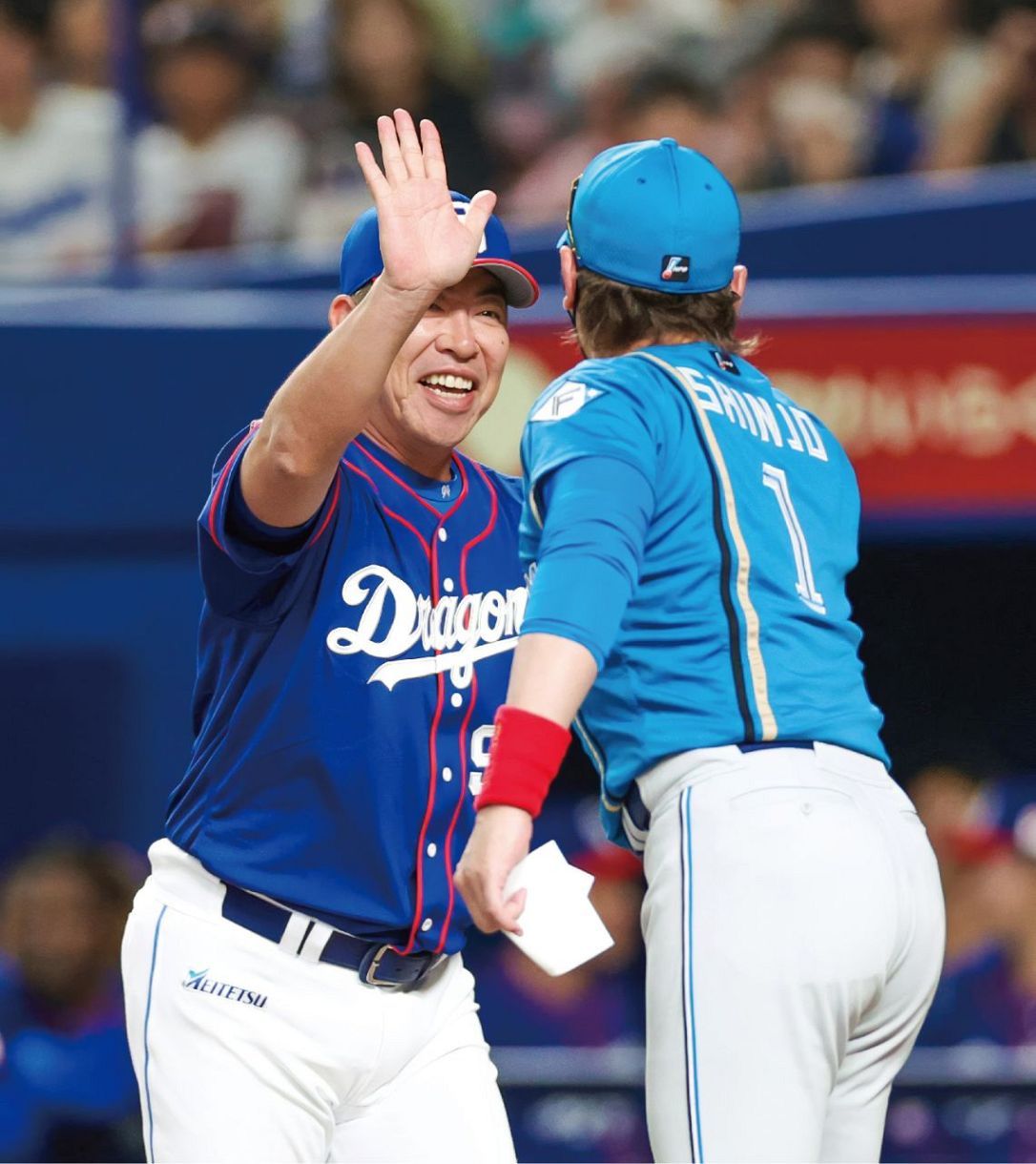 新庄監督（手前）とハイタッチをする井上監督＝６月２２日