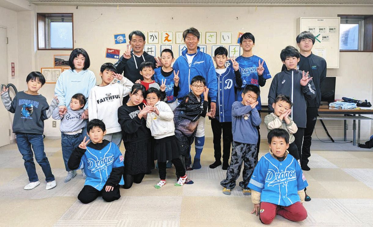 児童養護施設「旭が丘学園」の園児ら関係者と記念撮影する中日・山井コーチ（中）