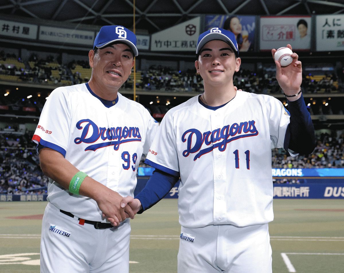 プロ初勝利を決め、井上監督（左）とポーズをとる中西