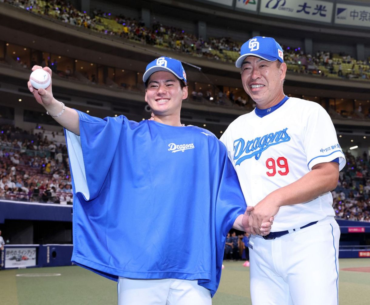 プロ初勝利を挙げ、井上監督㊨に祝福される金丸 
