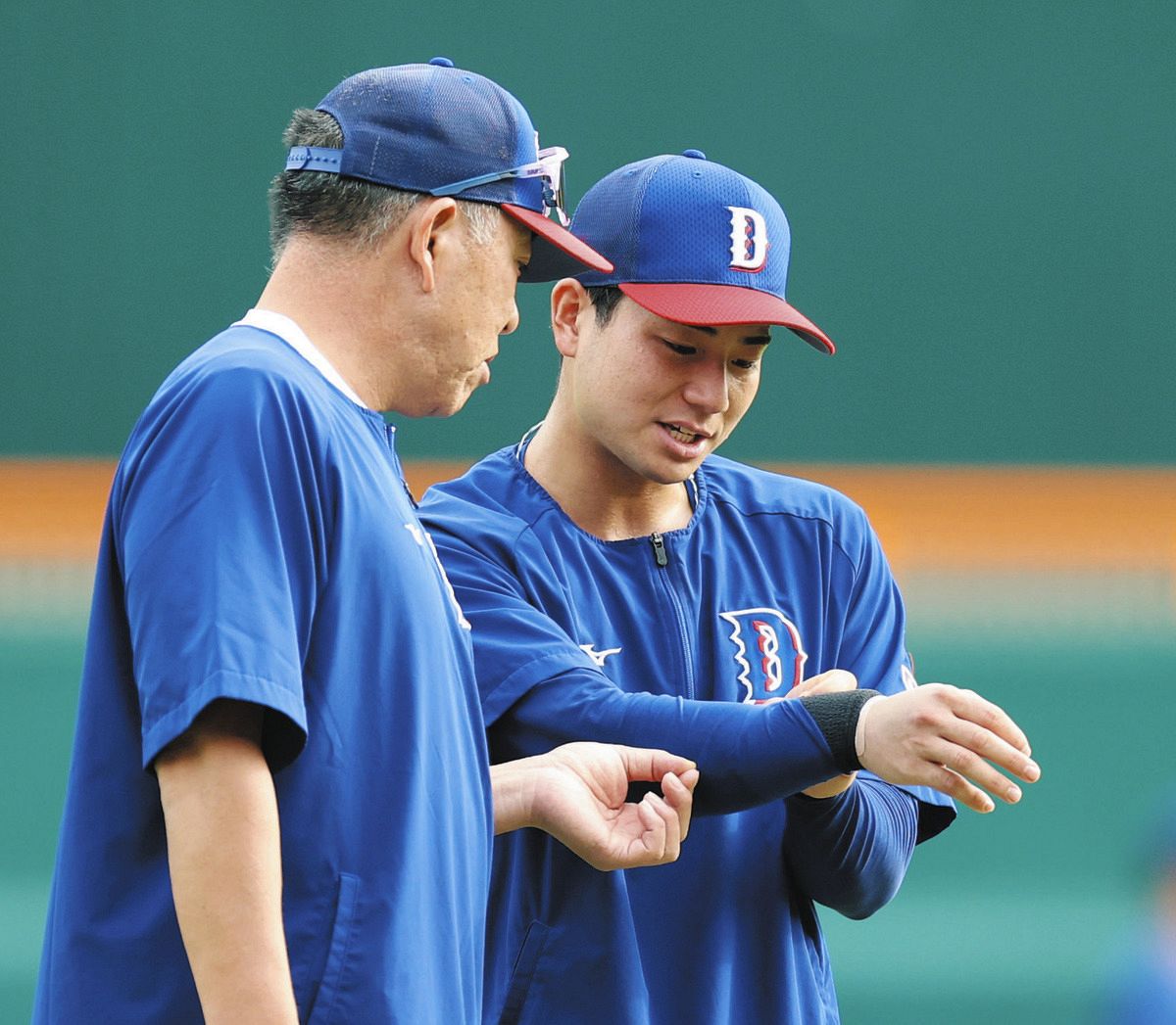 右腕を井上監督（左）に見せる石伊