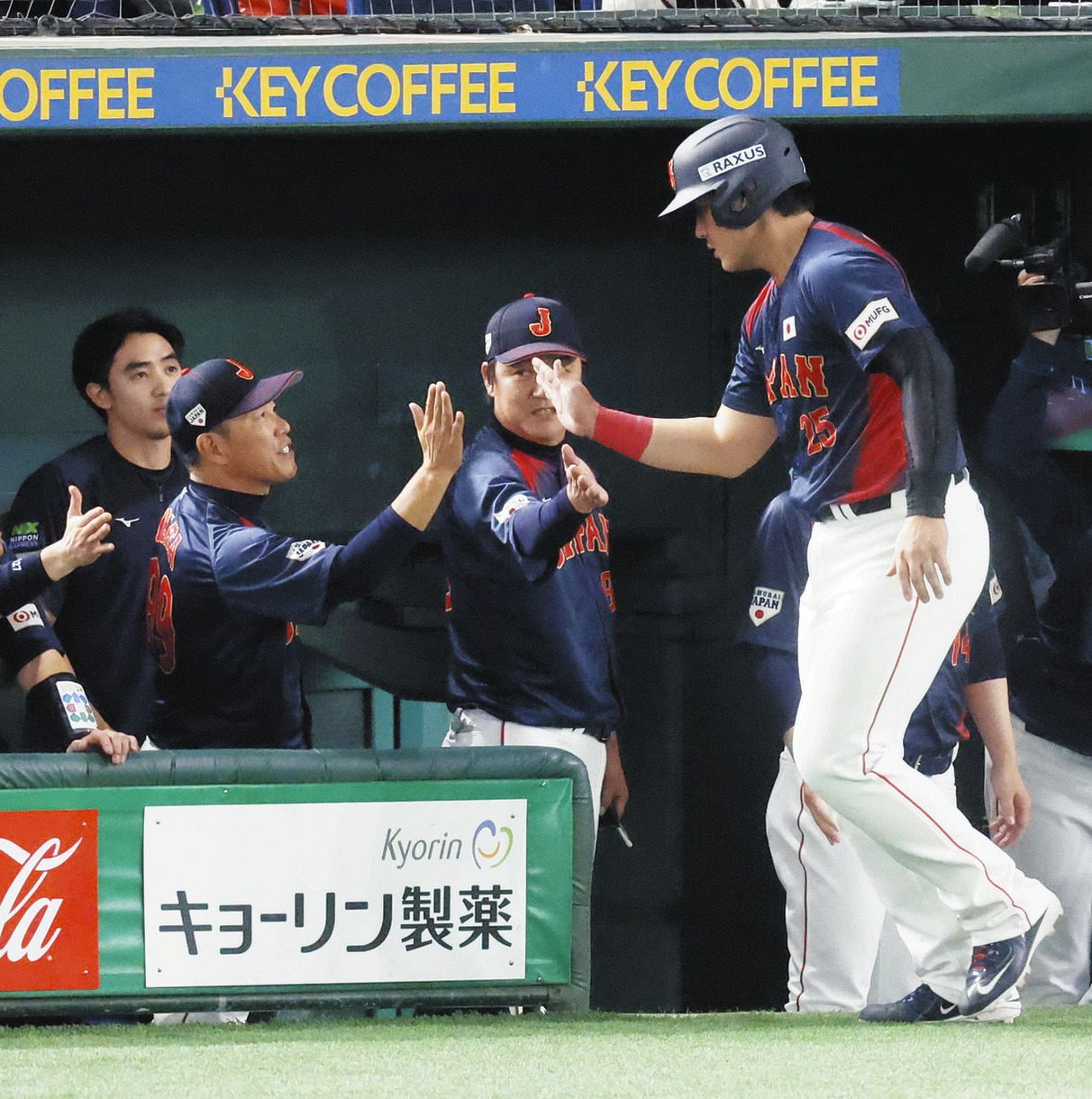 ８回表、生還した岡本（右）とタッチを交わす井端監督