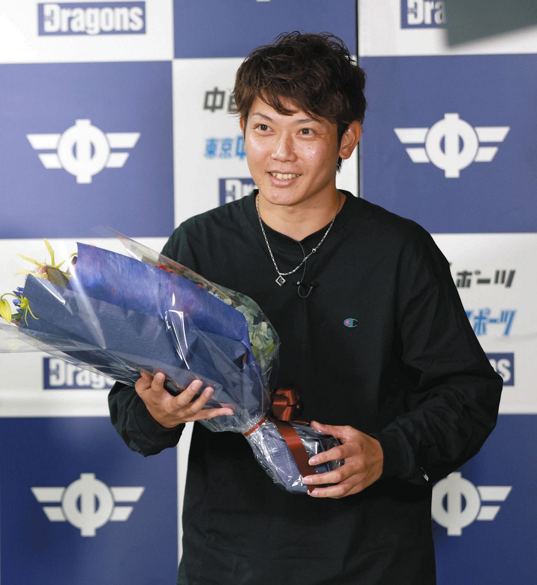 「ドラゴンズ情報」の生配信に出演し、花束を受け取る岡田俊哉さん