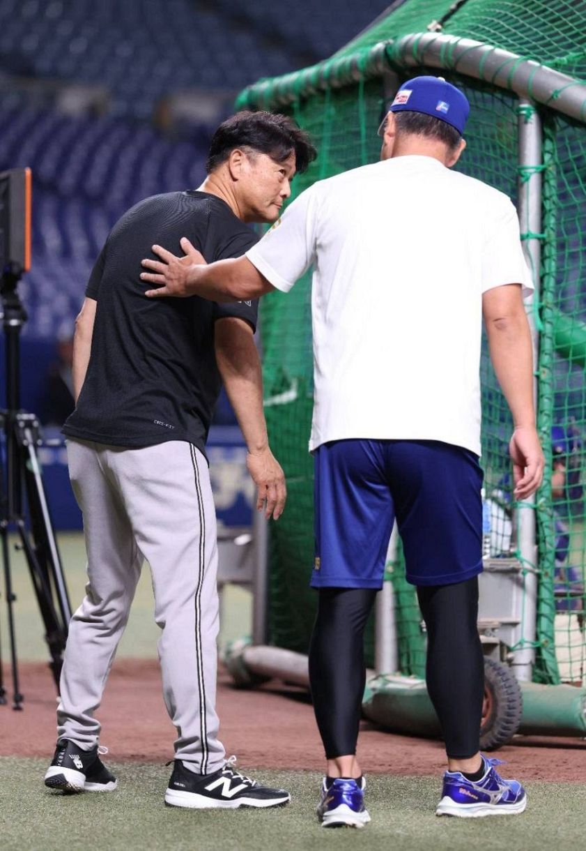 試合前、井上監督（右）と話す巨人・橋上監督代行